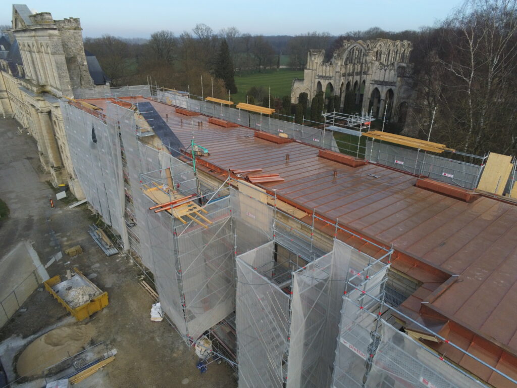 Vue aérienne du chantier de l'aile de Lorraine. On y voit les échafaudages dressés le long de la façade. 